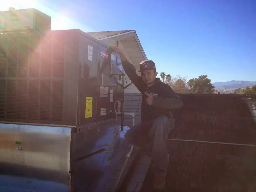HVAC technician performing Air Duct Cleaning on a rooftop unit in Grandview